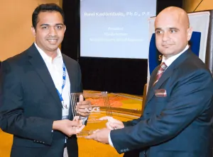 Dr. Ravi Kadambala, Senior Project Professional with the SCS office in Boca Raton, Florida receives the editor-in-chief award from Adnan Javed, President of the ASCE Florida Section.