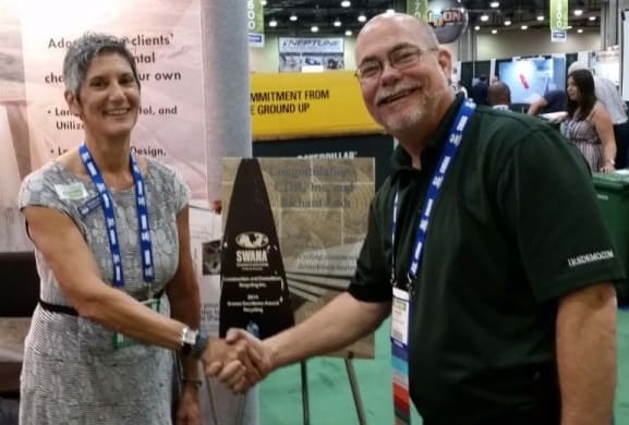 Richard Ludt, Director of Environmental Affairs receives a Bronze Award from SWANA President, Michelle Leonard of SCS Engineers. 